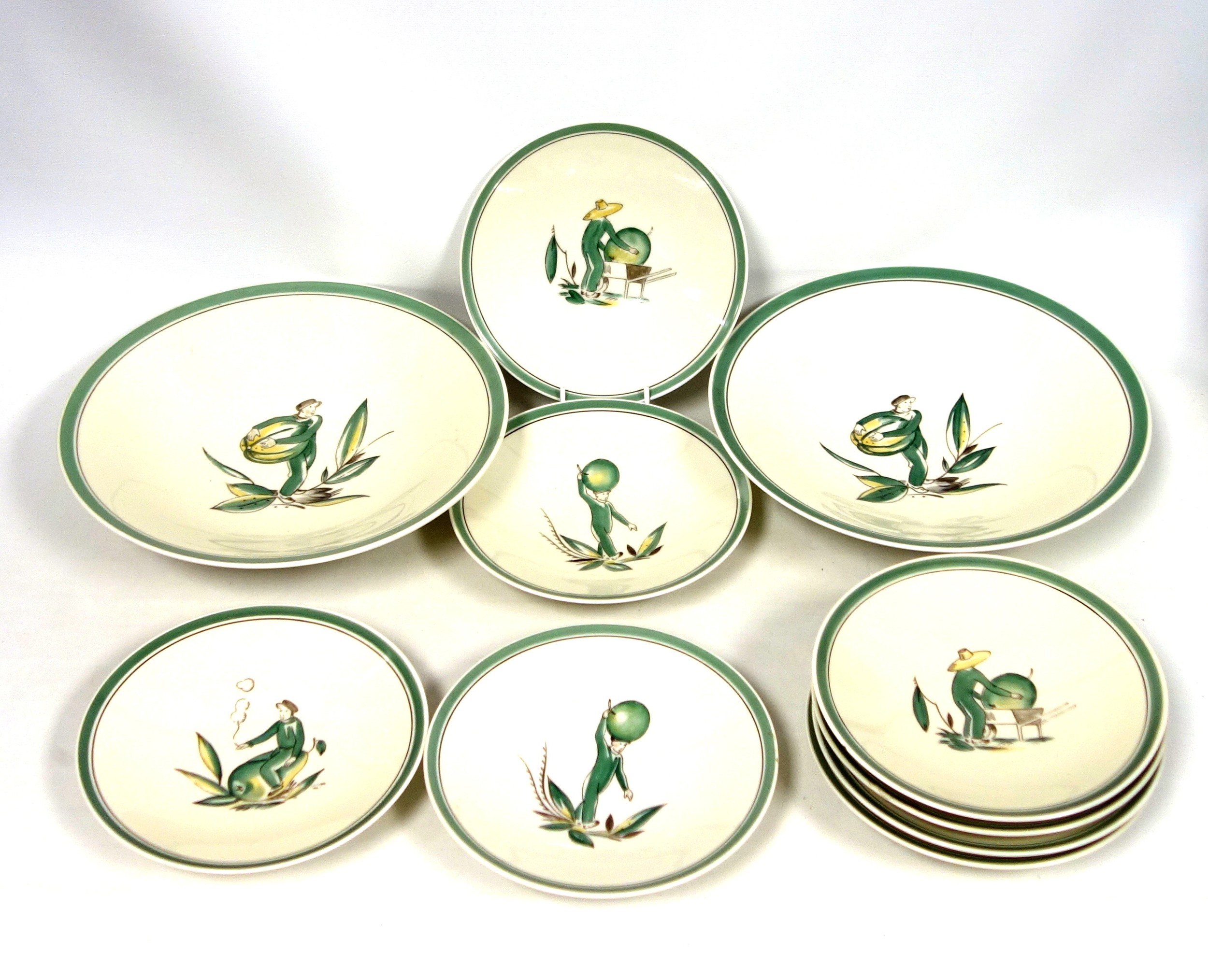 Royal Copenhagen part dessert service decorated with figures carrying fruit within a green border,