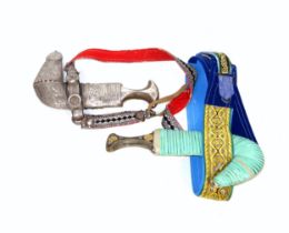 Yemeni white metal mounted Jambiya dagger in sheath with belt, with chased scrolling decoration, the