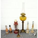 Metal oil lamp with an amber glass fount and Duplex wick adjusters, H.73.5cm; cranberry tinted