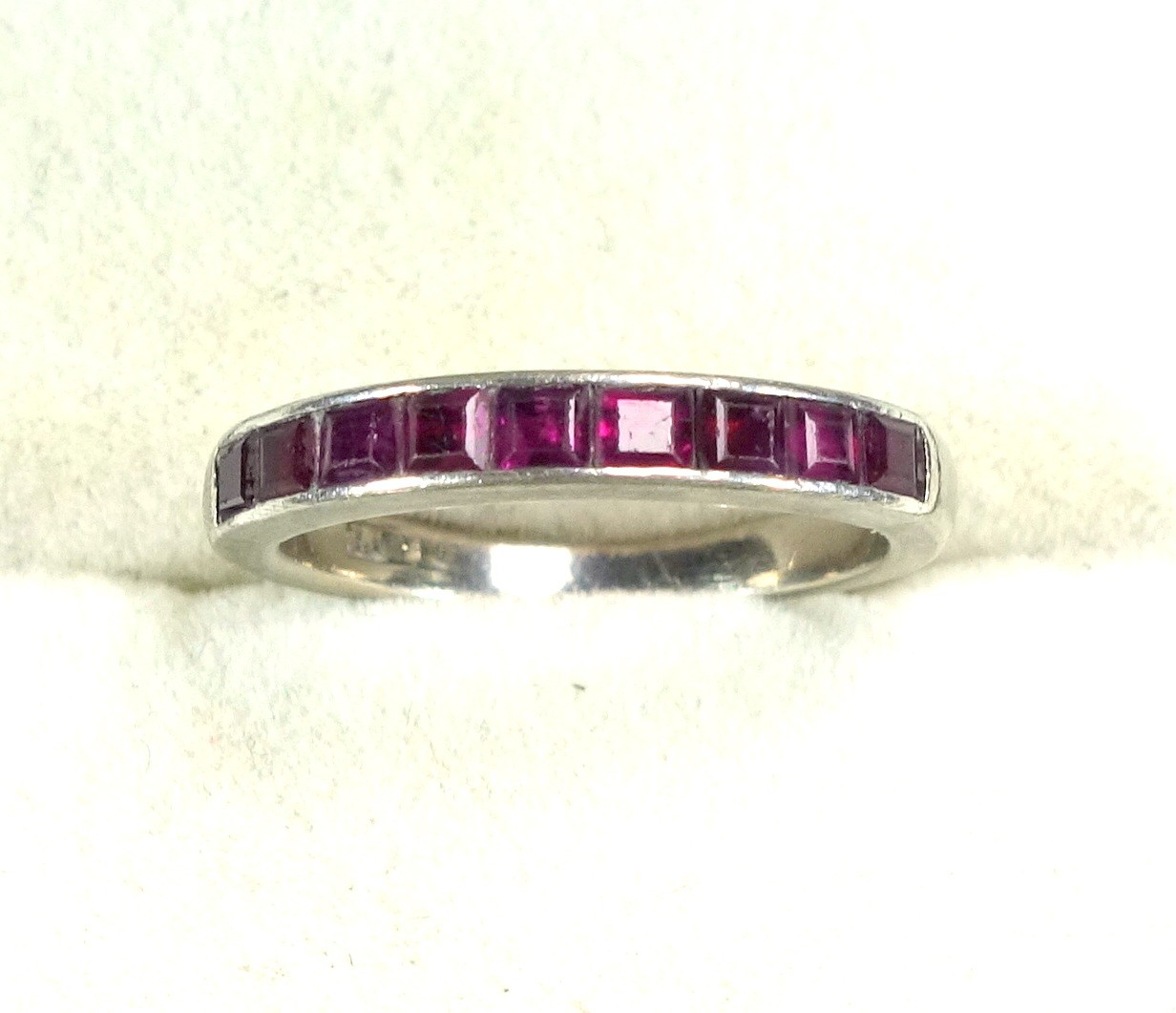 White metal 1/2 eternity ring set 9 rubies, stamped "18ct", 3.7grs