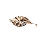 A gold 'leaf' shaped brooch, set with three brilliant cut diamonds, approx. 0.85 ct., clarity p2, 0.