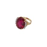 A vintage 14-kt gold ring, set with a modified step cut rubelite, of approx. 18.1 ct. and ten brilli