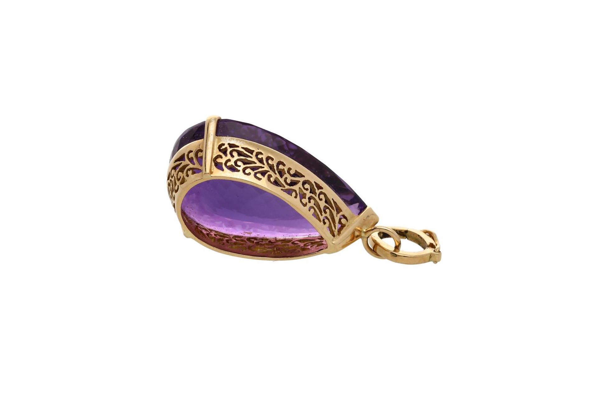 An 18-kt gold galerie ajour pendant, set with a pear cut amethyst of approx. 26.47 ct. H: 4.5 cm. To - Image 3 of 3