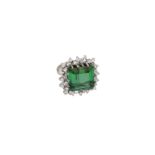 A white gold dubble entourage ring, set with an emerald step cut green tourmaline, approx. 19.57 ct.
