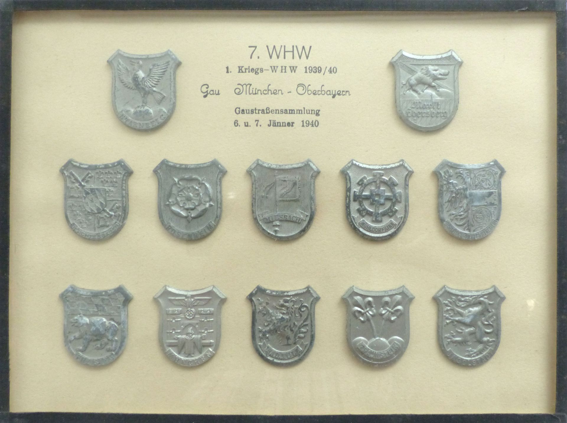 WHW Gau München-Oberbayern Gaustraßensammlung Januar 19340 12 Abzeichen im Rahmen 17,5 x24 cm I-II