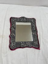 Ornate silver plated mirror with cherrub design measures approx 15 inches tall by 13 width