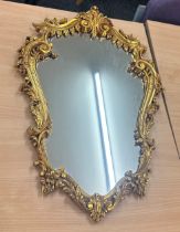 Vintage gilt framed mirror measures approximately 28 inches by 19 inches