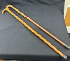 Two vintage wooden walking sticks one with Chinese writing , both with twisted detailing