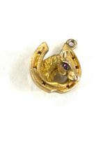 Hallmarked 9ct gold and ruby set horse within horse shoe charm , total weight 2.7g