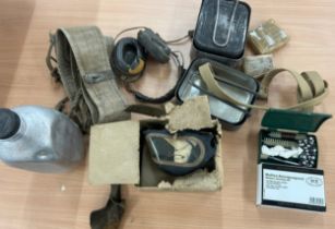 Selection of army supplies to include water bottle, gas mask, ammunition belt, field dressing kit