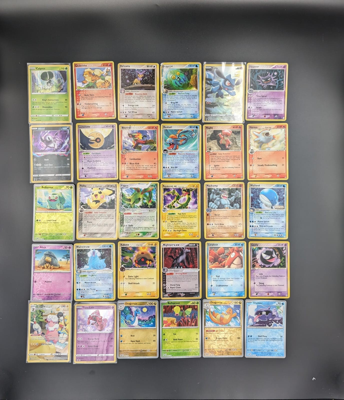 A collection of 30 Pokémon cards, some carefully sleeved and sourced from various series 2006-2022