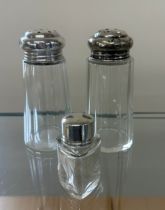 Two silver topped sugar shakers and silver topped perfume