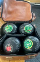 Set of four vintage lawn bowls to include Thomas Taylor and bag