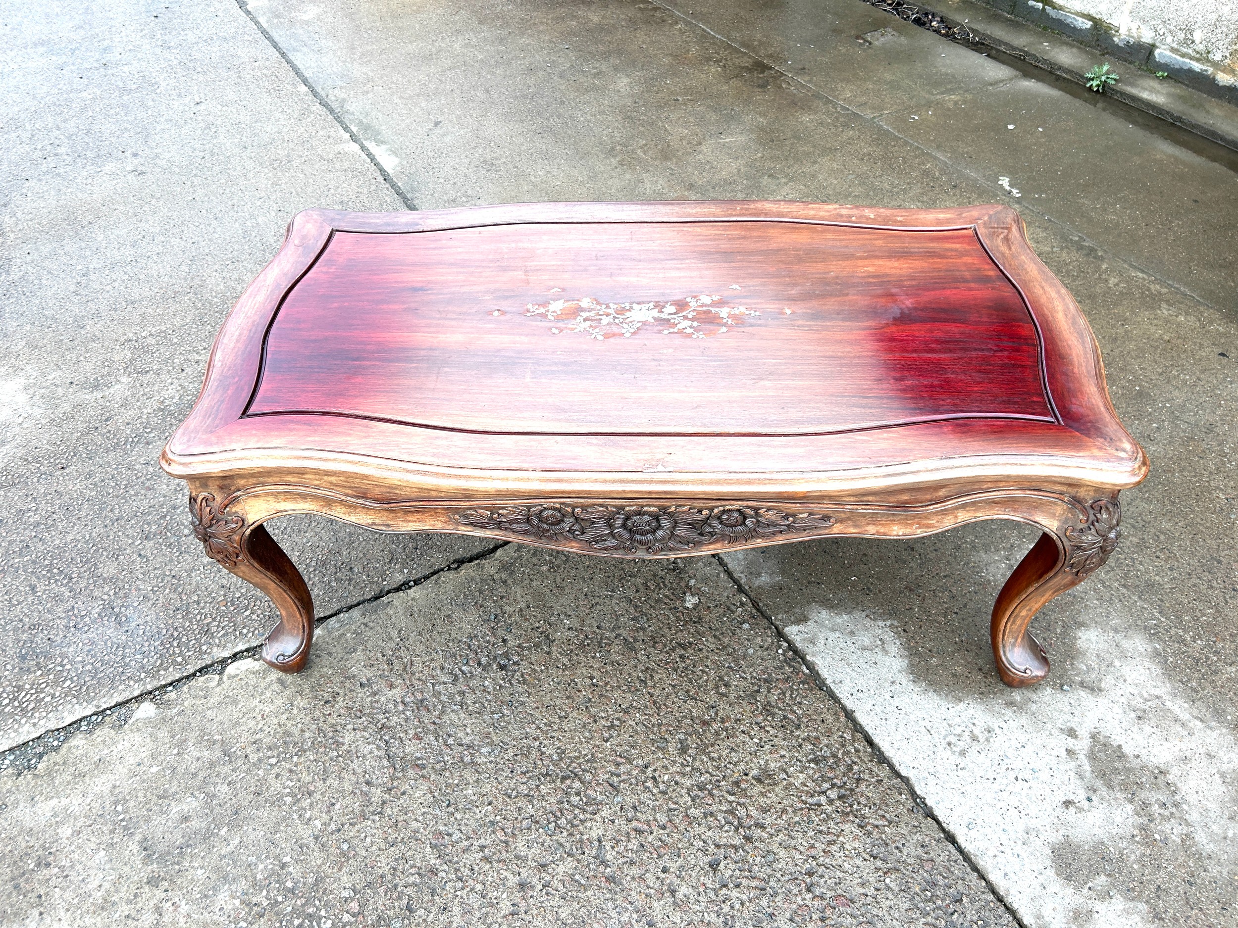 Mahogany inlaid coffee table with carved sides measures approx 21 inches tall, 48 wide and 27 deep