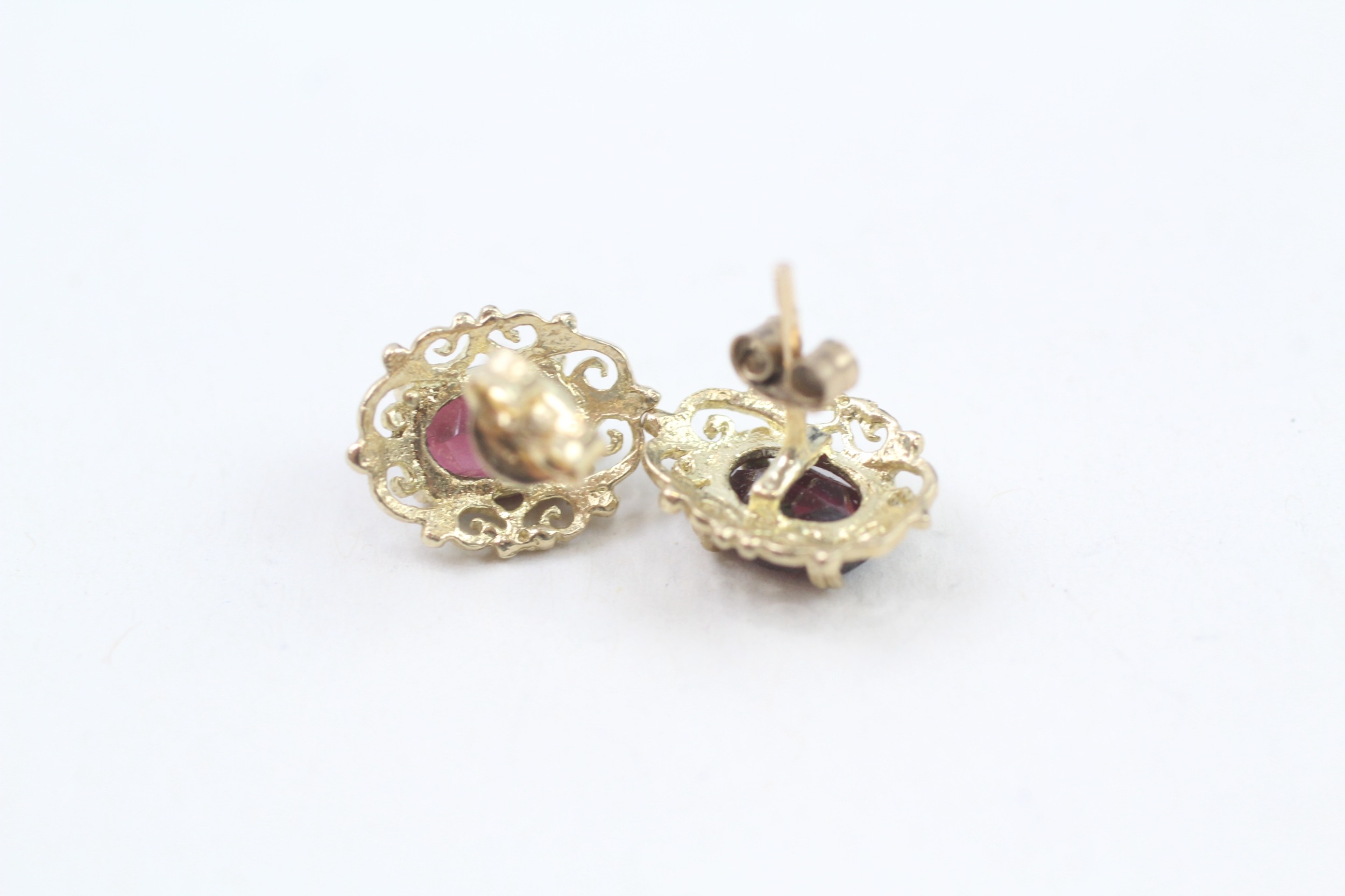 9ct gold oval cut garnet stud earrings with a scroll patterned border (1.7g) - Image 4 of 4