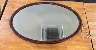 Mahogany inlaid oval mirror measures approximately 35 inches by 23 inches