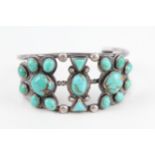 A silver Native American turquoise set bangle (60g)