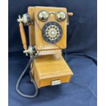 Vintage classic wall hanging phone in working order in an oak case