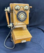Vintage classic wall hanging phone in working order in an oak case