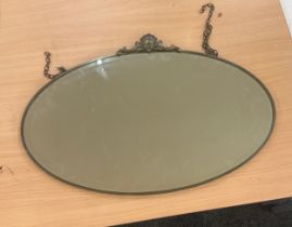 Oval shaped brass lined mirror measures approx 18 inches high by 27 wide