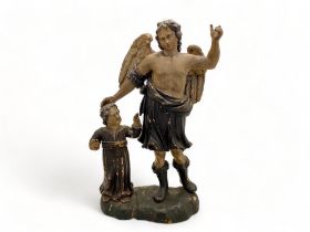 An 18th century polychrome carving of an angel blessing a child