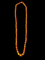A long single row butterscotch-look amber style bead necklace