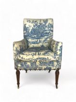 A 19th century oak armchair upholstered in blue toile de joie fabric