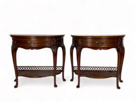A pair of late Victorian carved mahogany demi-lune console tables