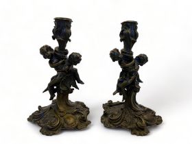 A pair of 19th century French Louis XV style patinated bronze candlesticks after a model by Meissonn