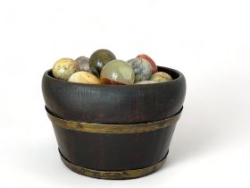 A coopered oak and brass bound oval bowl containing various mineral eggs