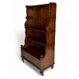 A tall William IV mahogany and ebonised four-tier waterfall bookcase