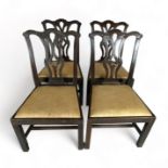 A set of four George III provincial carved mahogany dining chairs in the Chippendale style