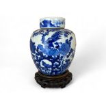 A Chinese blue and white ginger jar and lid on a pierced hardwood stand