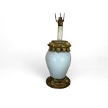An early 20th century Italian white glazed pottery and giltwood mounted lamp base