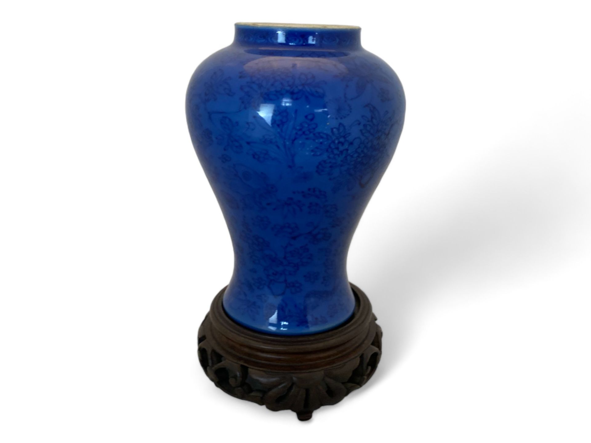 A 19th century Chinese porcelain blue self patterned monochrome baluster vase on a pieced hardwood