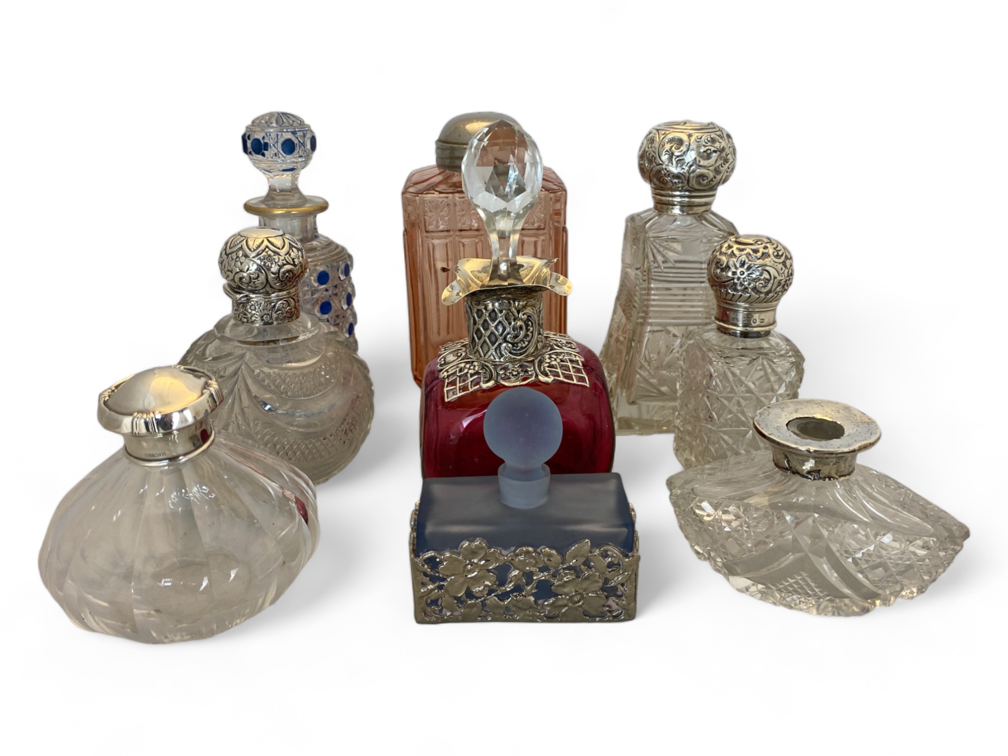A group of cut glass dressing table bottles mostly with silver fittings