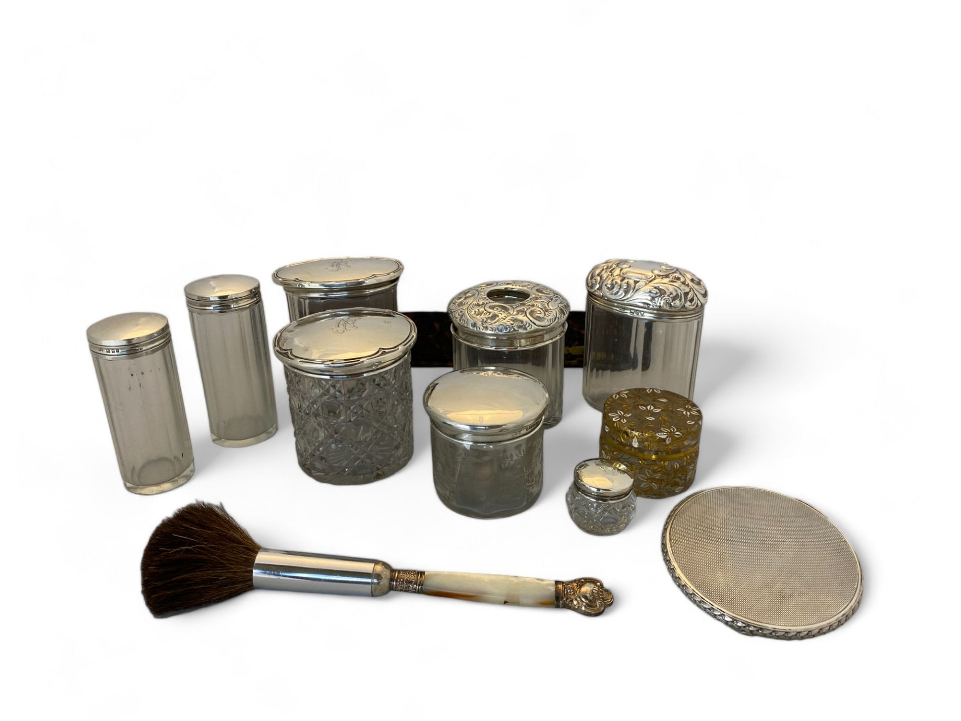 A group of silver and glass dressing table pots, silver compact and a cased bakelite vanity set