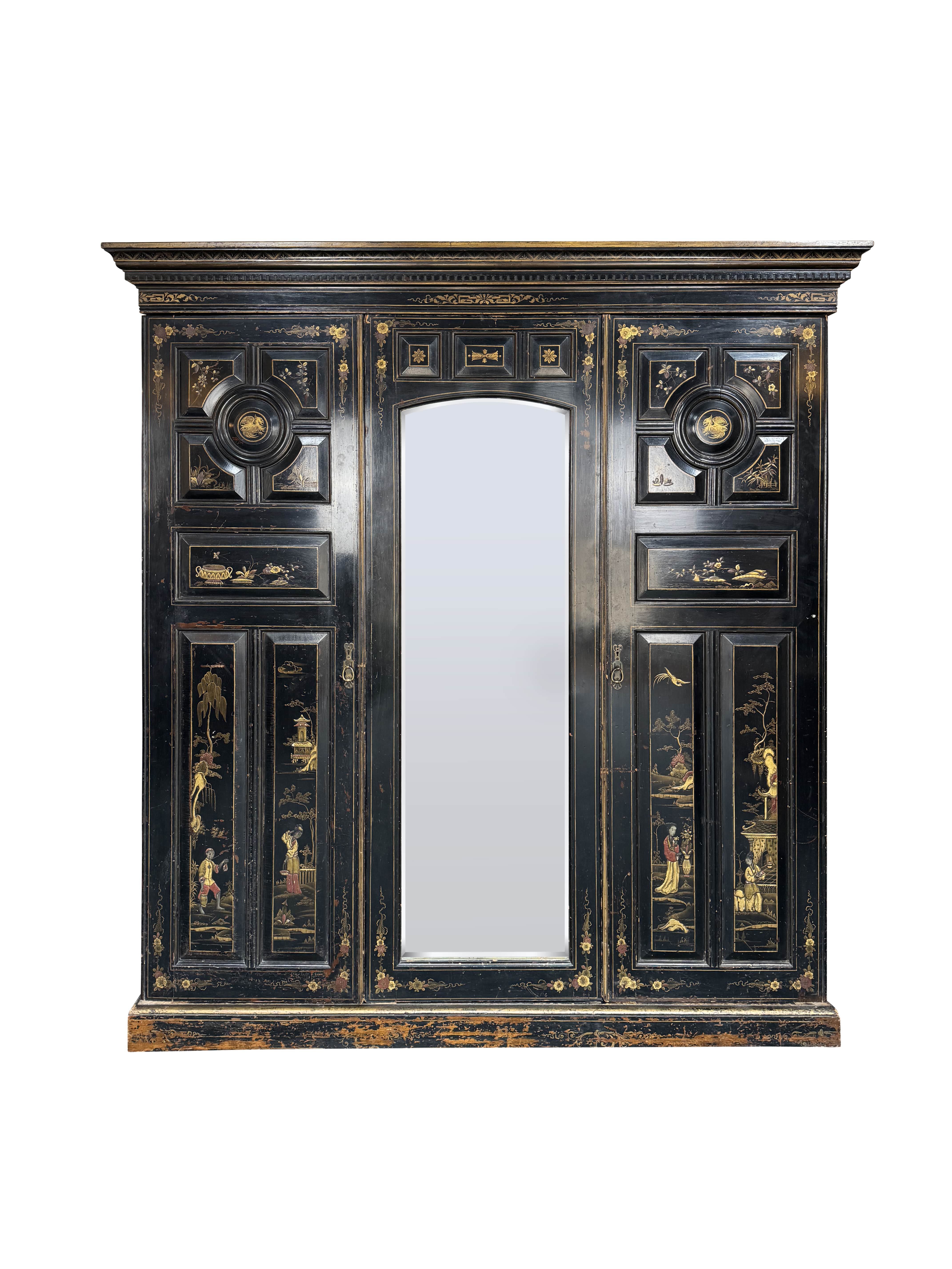 A Victorian Aesthetic period ebonised and decorated triple wardrobe