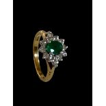 An emerald and diamond cluster ring