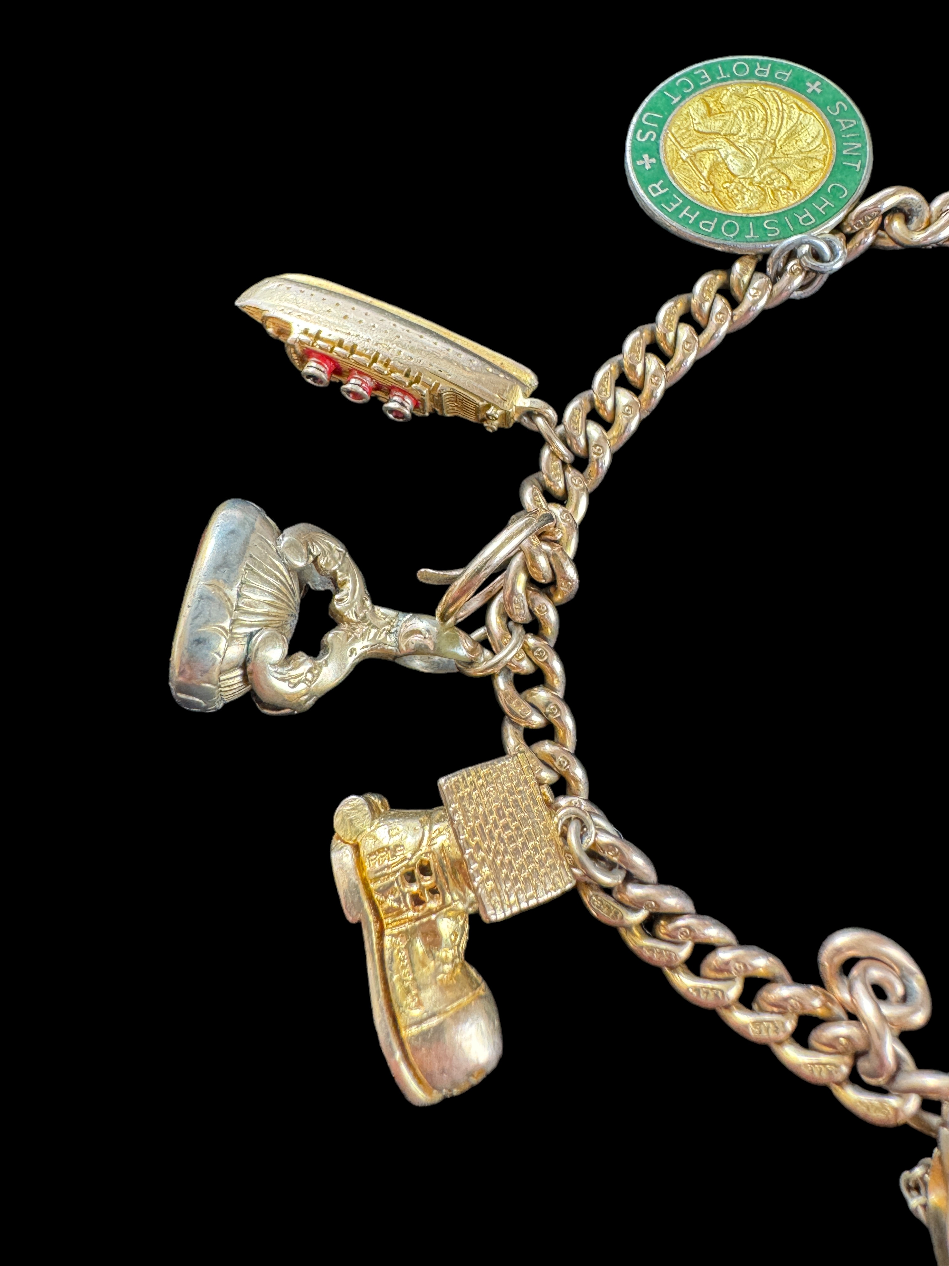 A 9ct gold curblink bracelet with 9ct gold heart padlock clasp and hung with ten charms, 1960s - Image 4 of 5