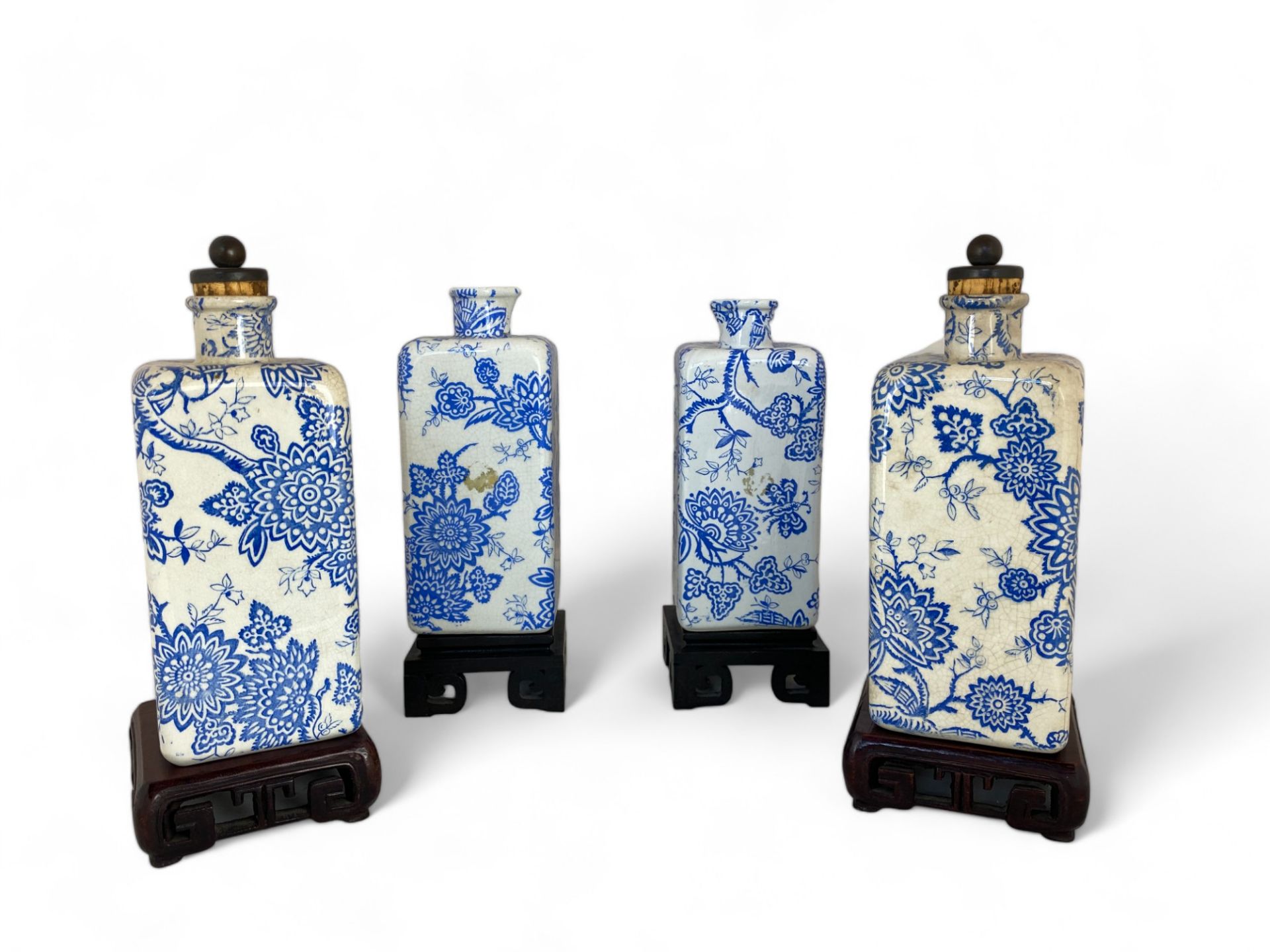 Two pairs of Liberty's blue and white foliate transfer printed bottles on Chinese hardwood stands