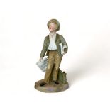 A 19th century bisque figure of a boy newspaper seller