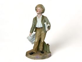 A 19th century bisque figure of a boy newspaper seller