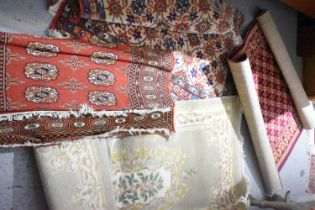 Four small rugs, to include two Middle Eastern examples, and two with floral patterns; one in pale
