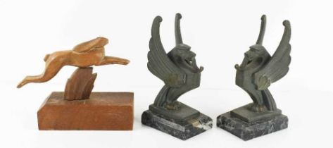 A pair of Art Deco bronze patinated metal griffins, raised on marble bases, 17cm high, together with