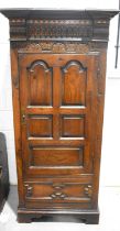 A 20th Century oak single door wardrobe in the 17th Century style, Phelps Ltd label inside of door,