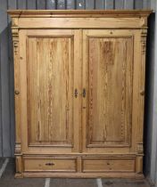 An antique pine double Wardrobe, with panel doors and two drawers, 195cm by 152cm by 60cm.