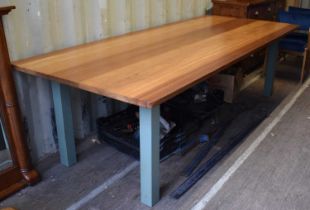 A large oak dining table raised on square legs, manufactured (made-to-measure) by Jamie Everett at