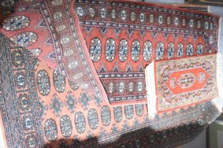 A Middle Eastern peach ground rug, a runner of similar pattern with darker peach ground, and a small