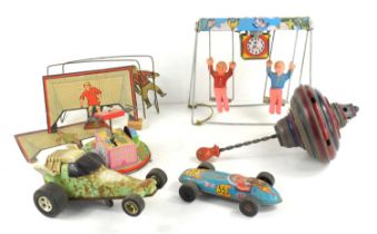 A group of vintage toys to include a tin plate wind up swing, wind up fairground ride, spinning top,